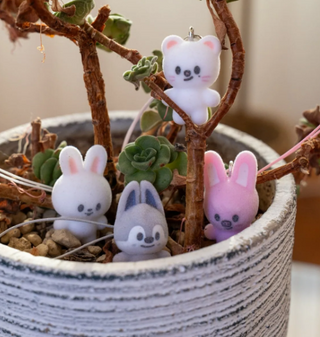 Small animal figurines in a pot with plants