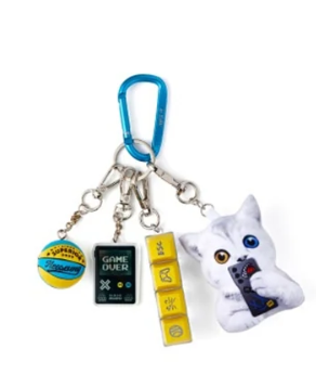 Keychain with a white cat figure, game console, and other charms on a white background