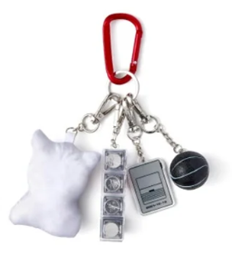 Keychain with various charms including a bell, camera, and other items on a white background
