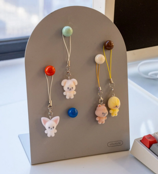 Set of colorful keychains shaped like animals on a gray stand.