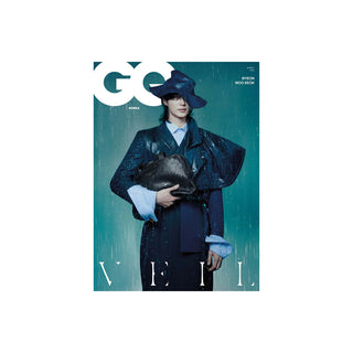GQ Korea magazine cover featuring a model in a dark blue raincoat and matching hat holding a black cat against a teal rain-streaked background.